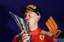 Sebastian Vettel kisses his trophy on the podium