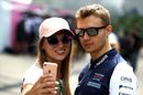 Sergey Sirotkin poses for a photo with a fan in the Paddock
