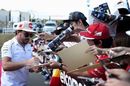 Fernando Alonso signs autographs for fans as he arrives