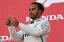 Race winner Lewis Hamilton celebrates on the podium