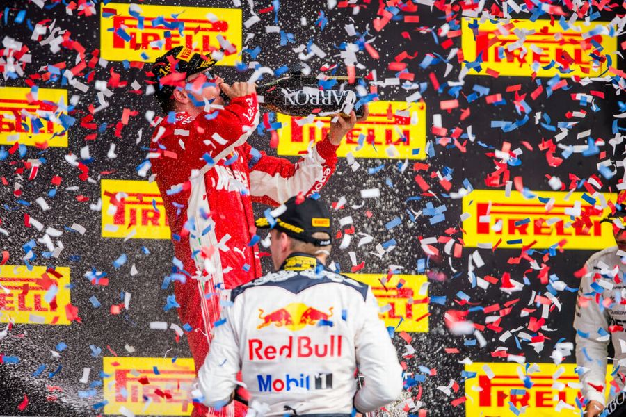 Race winner Kimi Raikkonen celebrates on the podium with the champagne