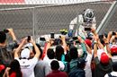 Fans take photos as Valtteri Bottas climbs from his car after stopping on track