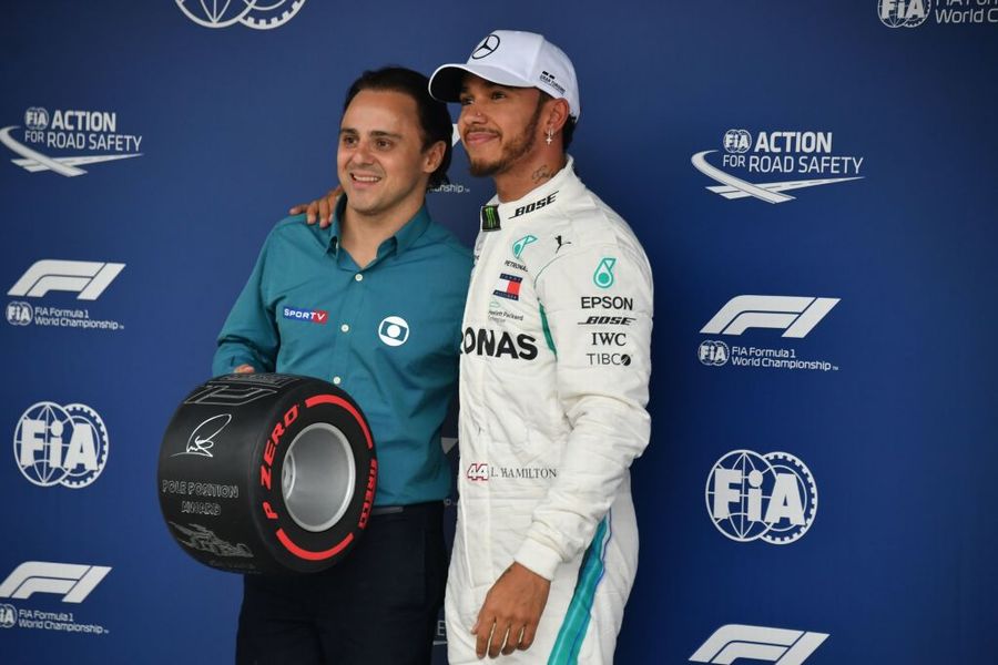 Pole sitter Lewis Hamilton receives the pole position award from Felipe Massa