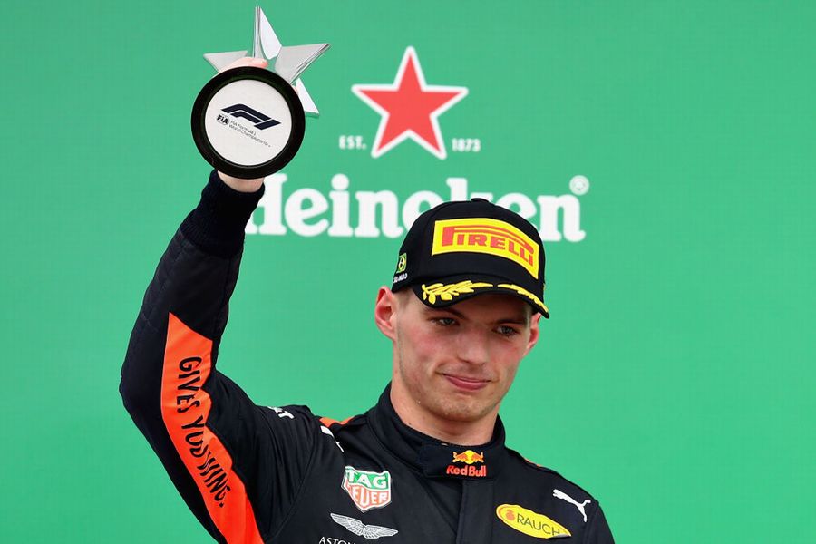 Max Verstappen celebrates on the podium with the trophy