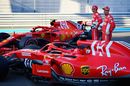 Kimi Raikkonen and Sebastian Vettel pose for a photo with their team in the Pitlane
