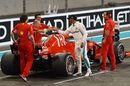 Pole sitter Lewis Hamilton shakes hands with Ferrari team members in parc ferme