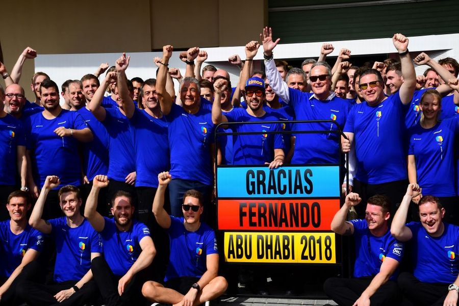 Fernando Alonso poses for a photograph with his team