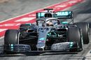 Lewis Hamilton powers down the pit lane in the Mercedes
