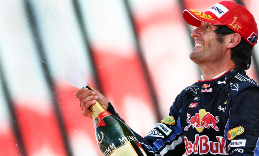 Mark Webber sprays the champagne on the podium
