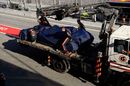 A tow truck loads Pierre Gasly's car after crashing