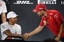 Sebastian Vettel shakes hands with Lewis Hamilton after a press conference