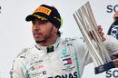 Lewis Hamilton celebrate on the podium with the trophy