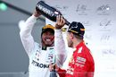 Lewis Hamilton and Sebastian Vettel celebrate on the podium with the champagne