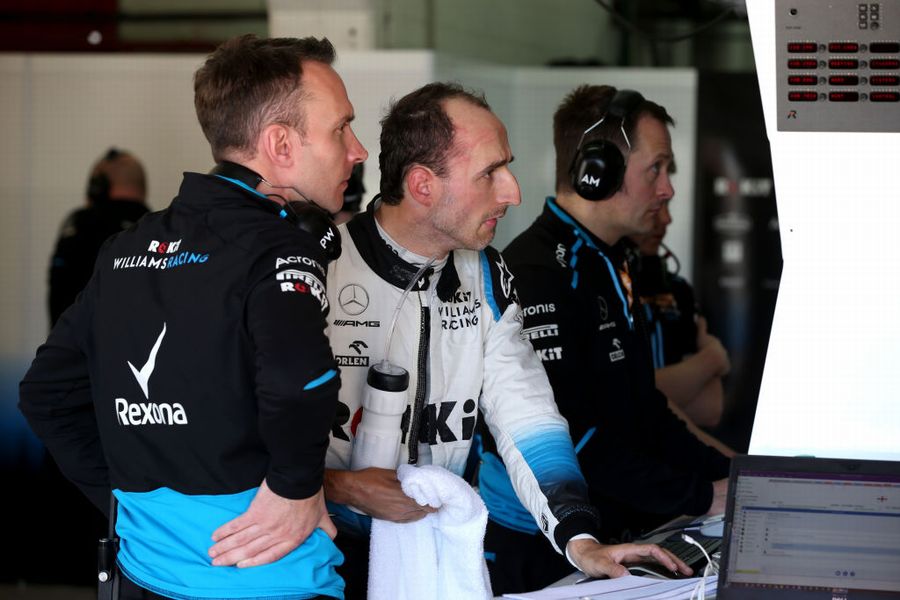 Robert Kubica talks with his engineers in the garage
