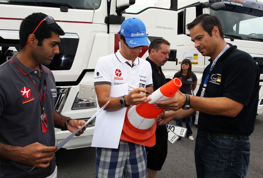 Bruno Senna signs a road cone after testing a truck