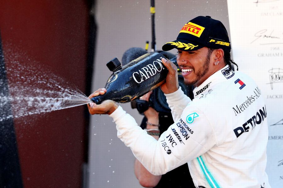 Race winner Lewis Hamilton celebrate on the podium with the champagne
