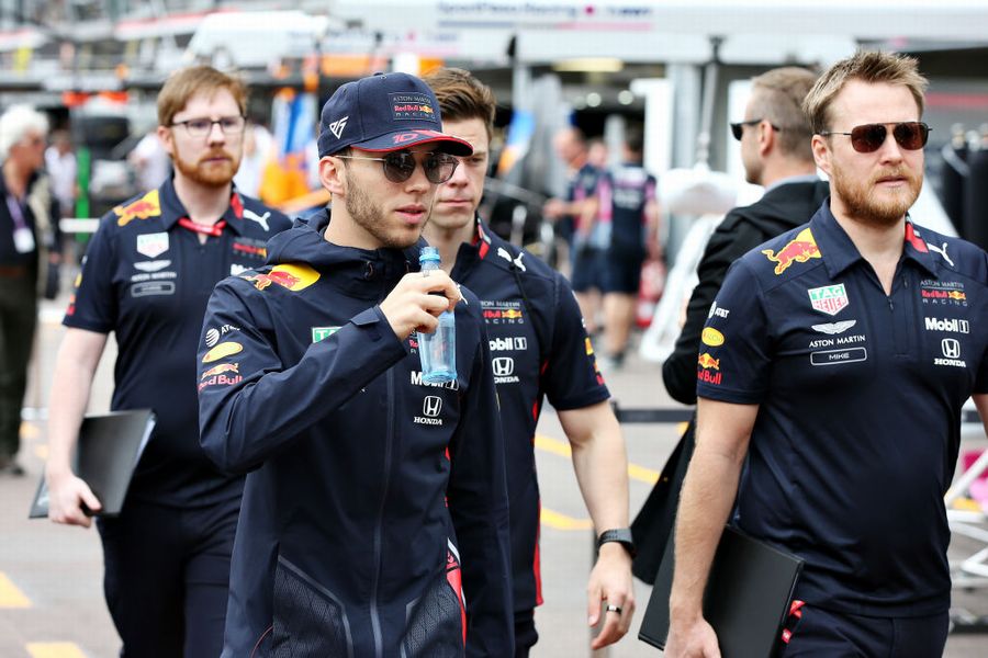 Pierre Gasly walks with his engineers in the Paddock