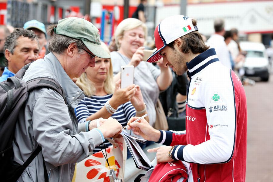 Antonio Giovinazzi signs autographs for fans in the Paddock
