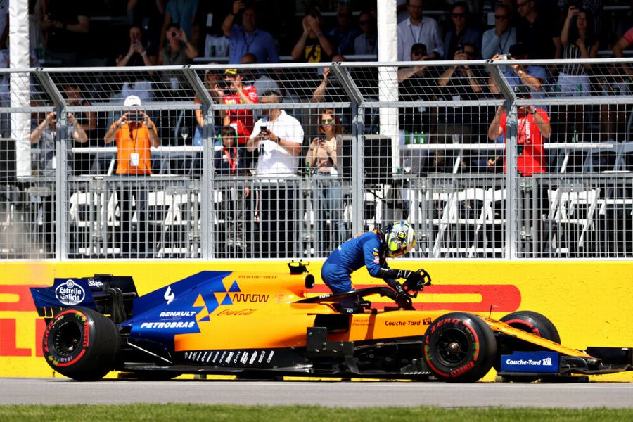 Lando Norris climbs from his car after retiring