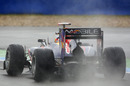Spray flies from the back of Sebastian Vettel's Red Bull