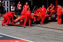 Ferrari mechanics wheel Sebastian Vettel back into the garage