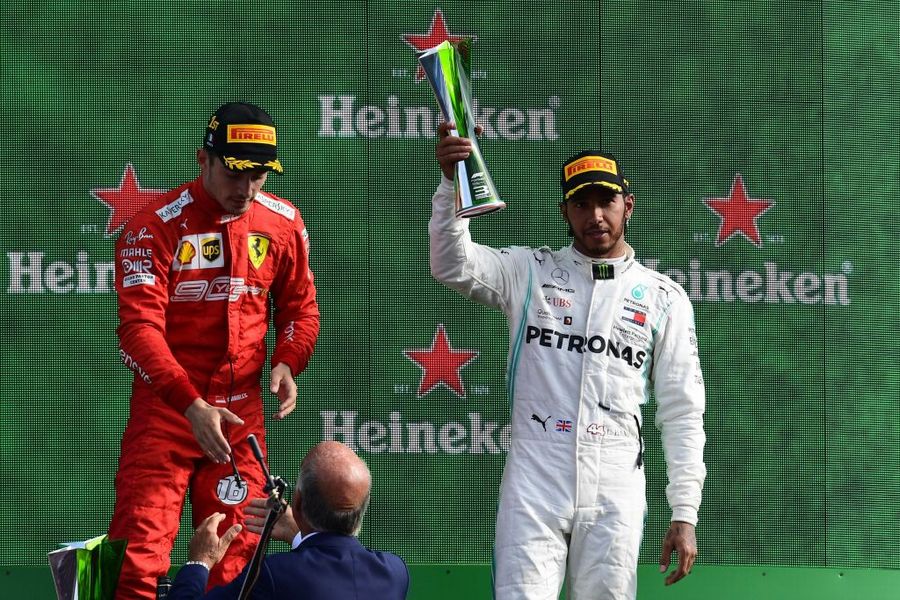 Lewis Hamilton celebrate on the podium with the trophy