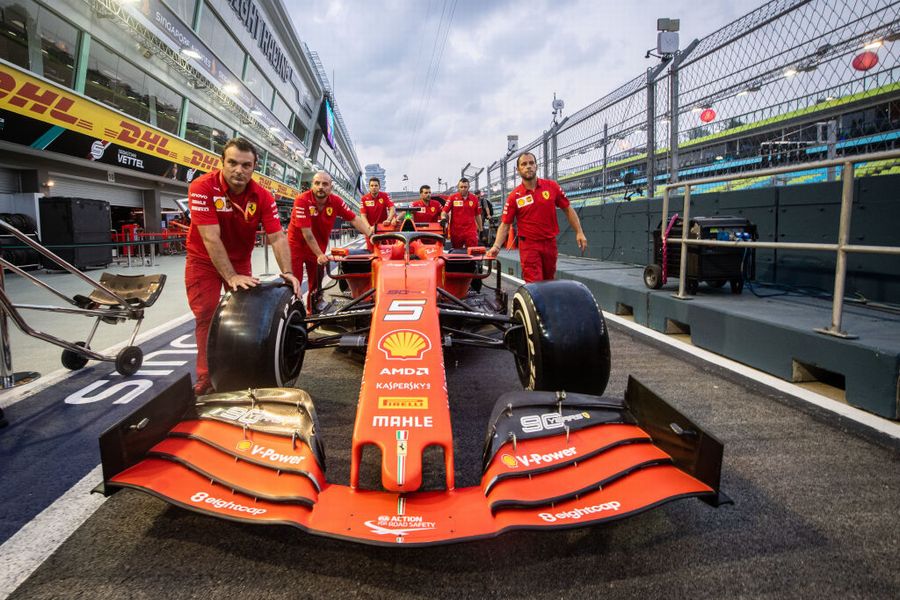 Ferrari mechanics push Sebastian Vettel's car