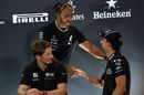 Lewis Hamilton shakes hands with Robert Kubica as Romain Grosjean looks on during a press conference