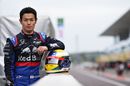 Naoki Yamamoto poses for a photo with his helmet in the Pitlane