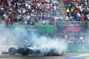 Race winner Lewis Hamilton celebrates in parc ferme by performing donuts