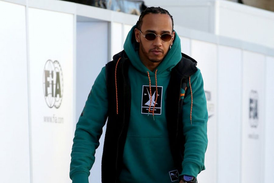 Lewis Hamilton rides a scooter in the Paddock