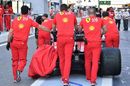 Ferrari pit crew push Sebastian Vettel's damaged car
