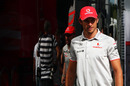 Jenson Button walks past the McLaren motorhome