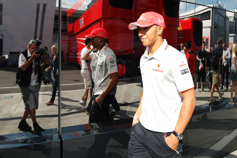 Lewis Hamilton walks past the McLaren motorhome