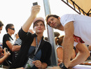 Mark Webber has his photo taken with a fan