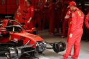 Sebastian Vettel looks at his car in the garage