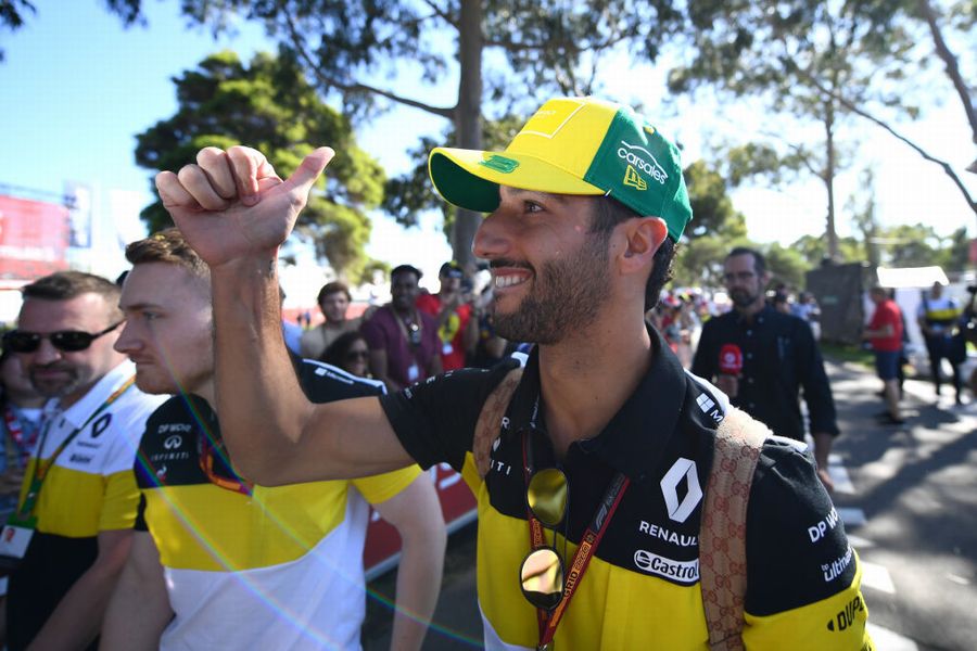 Daniel Ricciardo acknowledges fans as he arrives at the track