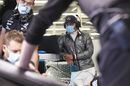 Valtteri Bottas wearing a facemask as Mercedes mechanics work on his car
