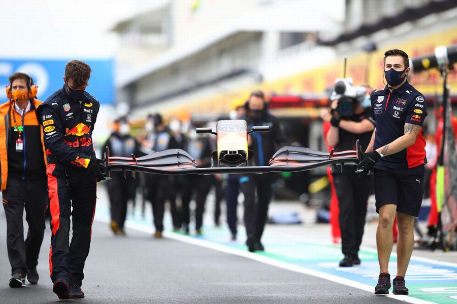 The Red Bull team bring a new front wing after Max Verstappen crashed on the way to the grid