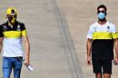 Daniel Ricciardo and Esteban Ocon walk in the Paddock