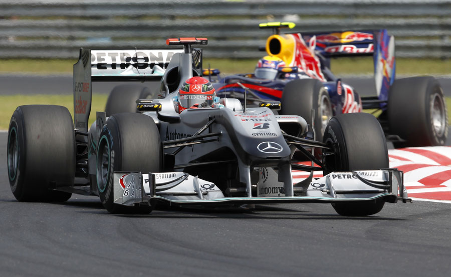 Michael Schumacher keeps an eye on his mirrors as Mark Webber closes in