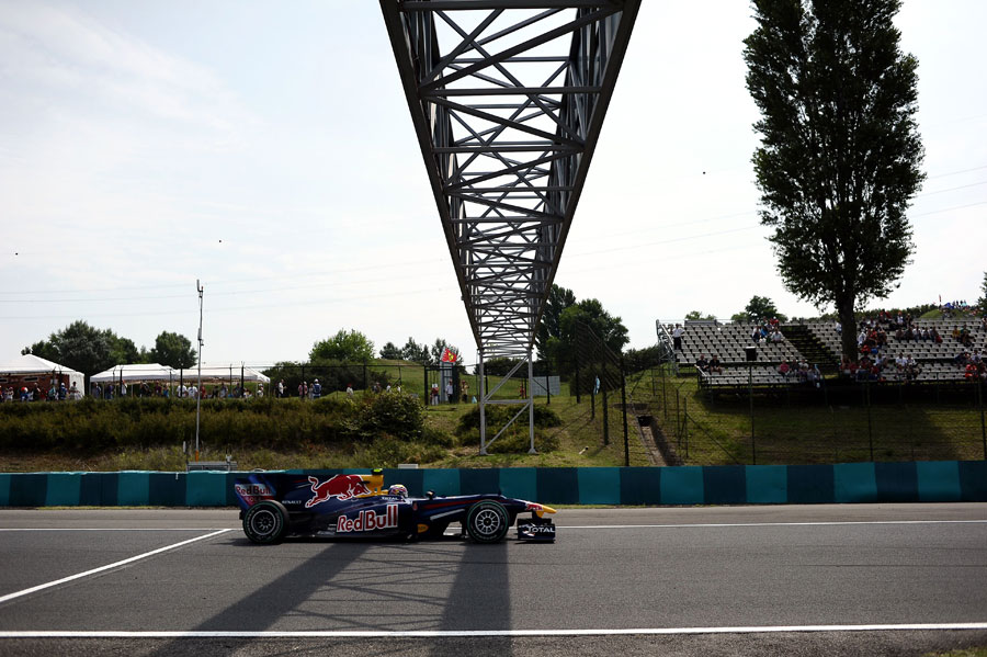 Sebastian Vettel flashes under the bridge