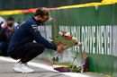 Pierre Gasly leaves flowers at the side of the track in tribute to the late Anthoine Hubert