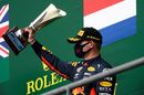 Max Verstappen celebrates on the podium with the trophy