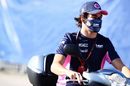 Lance Stroll rides a scooter in the Paddock