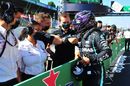 Pole sitter Lewis Hamilton celebrates with a team member in parc ferme