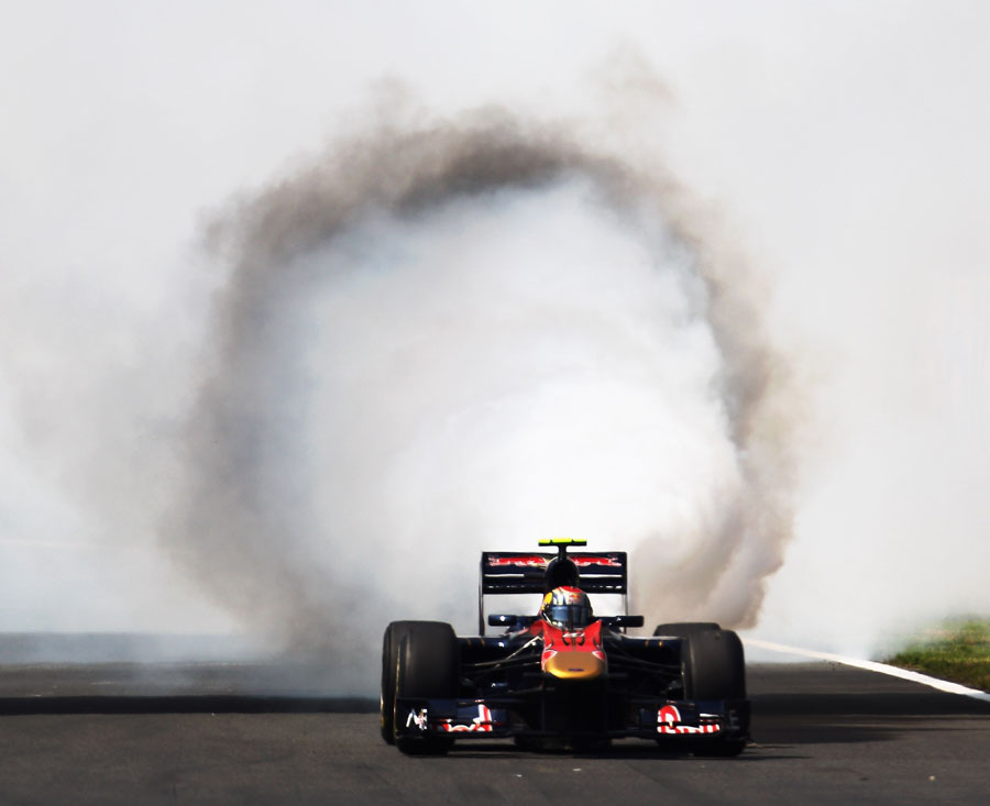 Smoke billows from the back of Jaime Alguersuari's Toro Rosso at the start