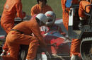 Marshals get to work after Andrea de Cesaris crashes out of the Japanese GP