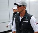 Michael Schumacher and Nico Rosberg stroll through the paddock