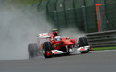 Fernando Alonso throws up a plume of spray at a wet Spa
